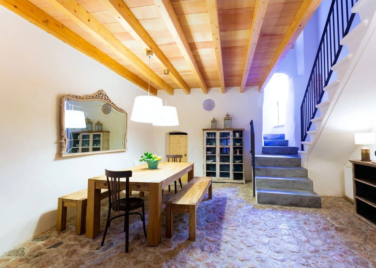 A dining room with wooden furniture and stairs.