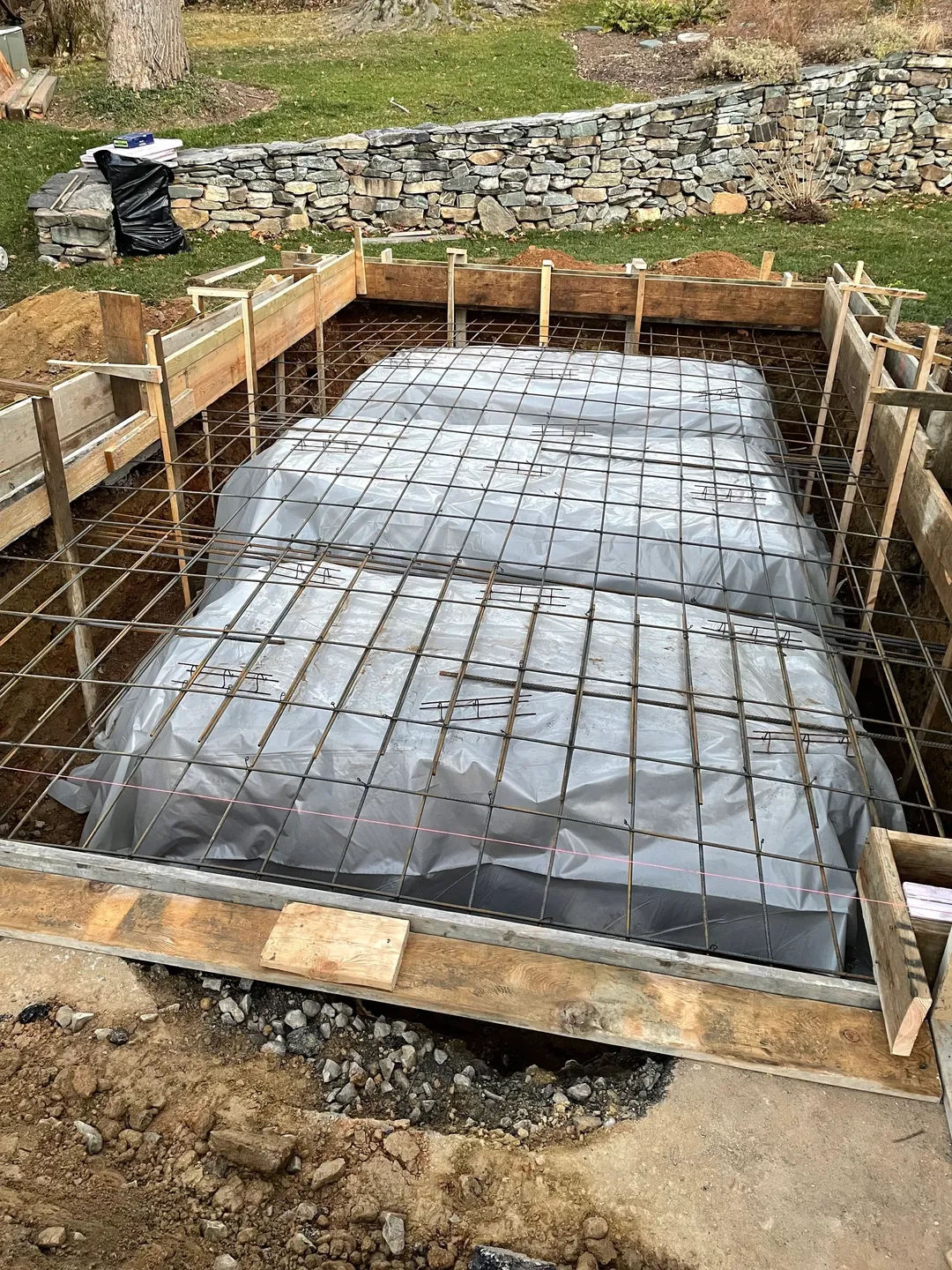 A construction site with some concrete and plastic sheeting.