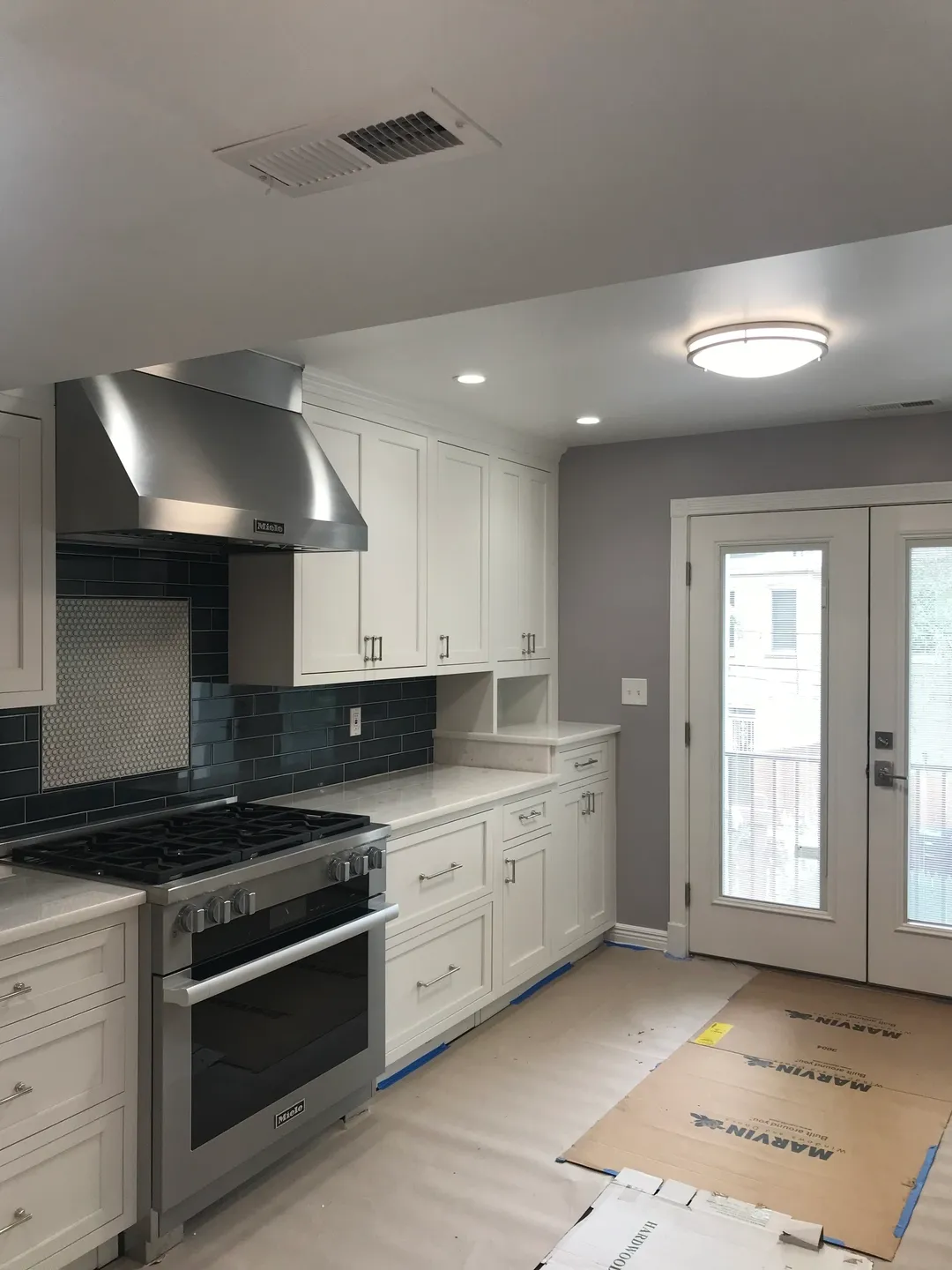 A kitchen with white cabinets and stainless steel appliances.