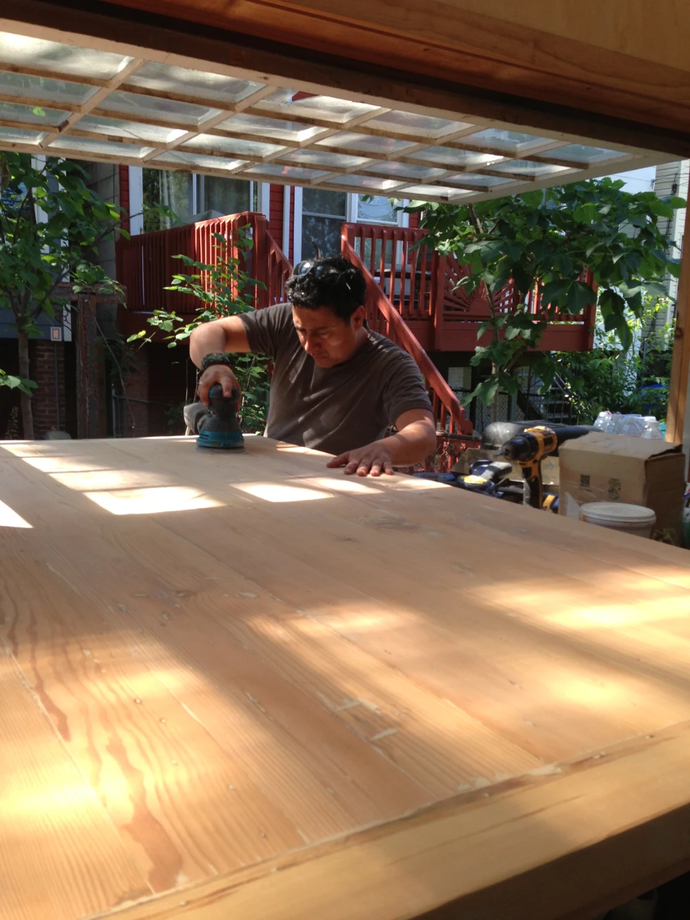 A man working on a table in the sun.