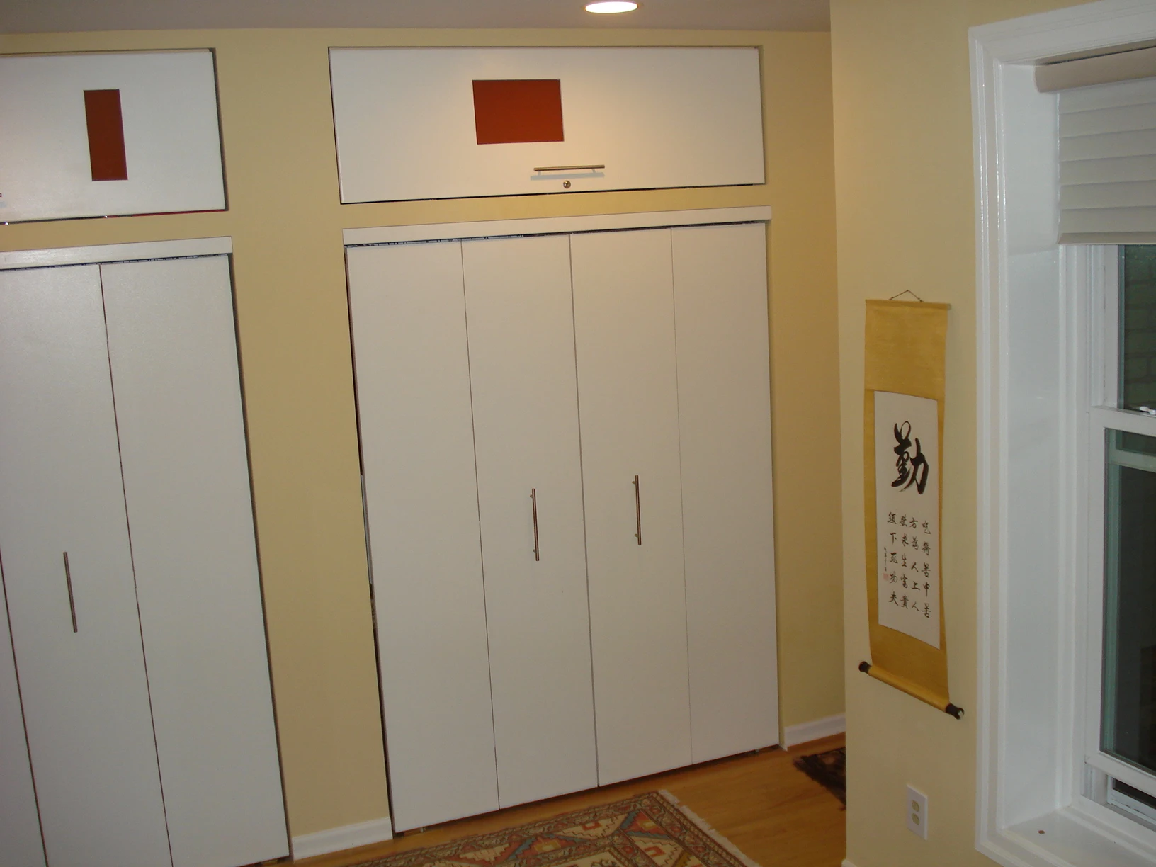 A room with two white doors and a red sign.