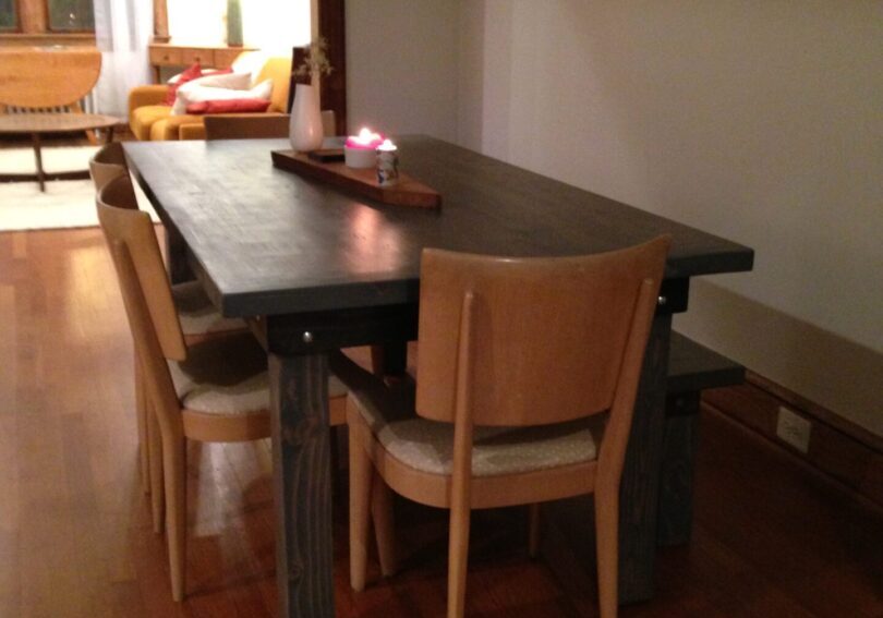 A dining room table with chairs and a tray on top of it.